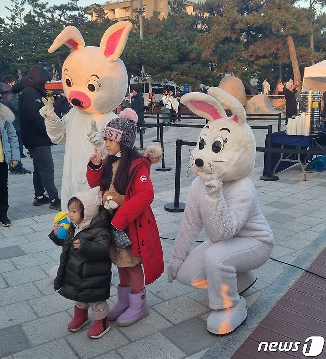 2023년 계묘년(癸卯年) 새해 첫 날인 1일 오전 3년 만에 해맞이 축제가 열린 강원도 강릉시 경포해변에서 시민들이 토끼와 기념촬영을 하고 있다.2022.1.1/뉴스1 윤왕근 기자 ⓒ News1 윤왕근 기자