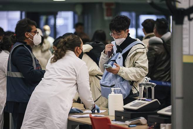 중국을 출발해 지난 29일(현지 시각) 이탈리아 밀라노 말펜사 국제공항에 도착한 여행객이 코로나 검사를 받고 있다. /AP 연합뉴스