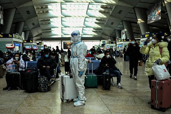 중국 베이징 기차역에 한 승객이 방역복을 갖춰 입고 서있다. [이미지출처=AFP 연합뉴스]