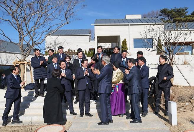 문재인 전 대통령 내외와 더불어민주당 이재명 대표 등이 2일 경남 양산시 하북면 평산마을 문 전 대통령 사저에서 단체 사진 촬영을 한 뒤 박수를 치고 있다. 더불어민주당 제공