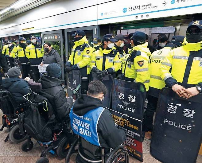 “출근길 막는 것은 안됩니다” - 2일 서울 지하철 4호선 삼각지역 승강장에서 경찰들이 ‘출근길 탑승 시위’를 하려는 전국장애인차별철폐연대(전장연) 관계자들을 막고 있다. 경찰과 서울교통공사가 이런 방식의 시위를 원천 봉쇄한 것은 출근길 시위가 시작된 2021년 12월 이후 13개월 만에 처음이다. /연합뉴스