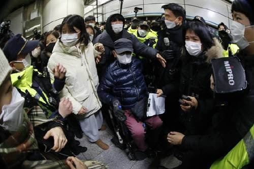 전국장애인차별철폐연대(이하 전장연) 활동가들이 3일 오전 서울 동대문역사공원역에서 지하철 승차를 막는 경찰과 대치하고 있다. 뉴스1