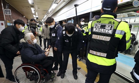 박경석 전장연 상임공동대표가 3일 서울 용산구 삼각지역에서 지하철에 탑승하려다 지하철보안관들에게 막히고 있다.