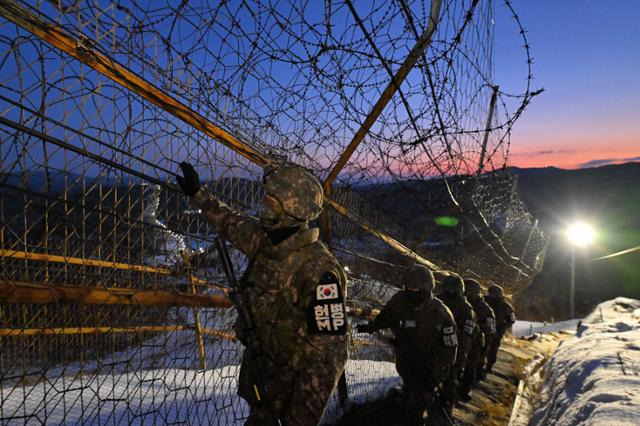 경기 연천군 육군 제5보병사단 독수리여단 GOP 부대 장병들이 동트는 새벽녘이지만 아직은 어둠이 가득한 가운데 경계등의 불빛 아래에서 DMZ 완전 경계 작전 성공을 위해 철책선을 정밀 점검하고 있다. 연천=왕태석 선임기자