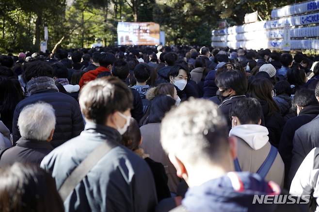 [도쿄=AP/뉴시스] 3일 일본 도쿄의 메이지 신궁에서 새해 행운을 빌러 온 '하츠모데' 방문객들이 순서를 기다리고 있다. '하츠모데'는 새해에 처음으로 신사를 참배하는 행사로 사람들은 신에게 지난 1년 동안 돌봐주신 것에 감사하고 새해의 평안을 빈다. 2023.01.03.