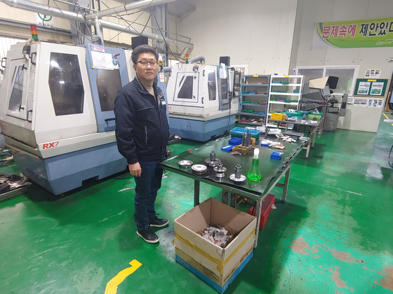 Sungsan Tool’s CEO Lee In-su looks over the factory machines on Jan. 2 in Changwon. [JEONG JONG-HOON]