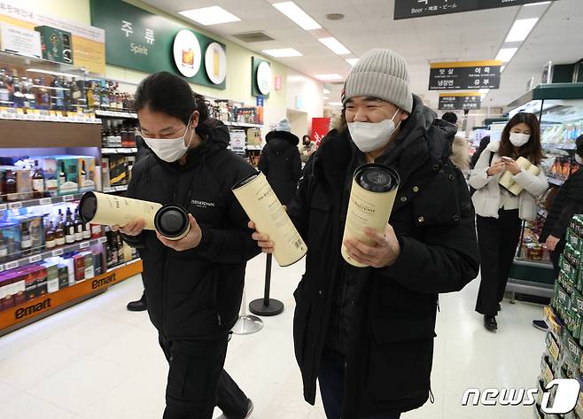 6일 서울 이마트 용산점에서 시민들이 한정판 위스키를 구매한 후 미소 짓고 있다. 이마트는 오는 7일까지 발베니, 맥켈란을 비롯해 2022년 인기 위스키 7종 할인 행사를 진행한다. 2023.1.6/뉴스1 ⓒ News1 신웅수 기자