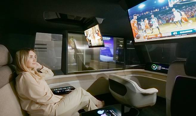 미국 라스베이거스에서 LG디스플레이 모델이 ‘차량용 18인치 슬라이더블 OLED’로 영상을 감상하고 있다. <사진 제공=LG디스플레이>