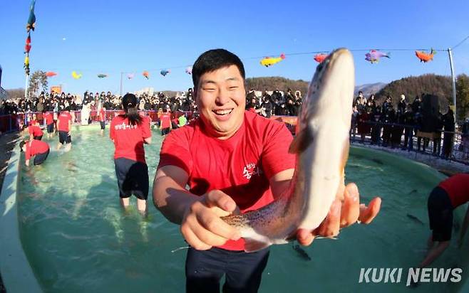 6일 오전 '송어맨손잡기' 행사에 참여한 한 체험객이 송어를 잡고 밝은 표정을 짓고 있다.