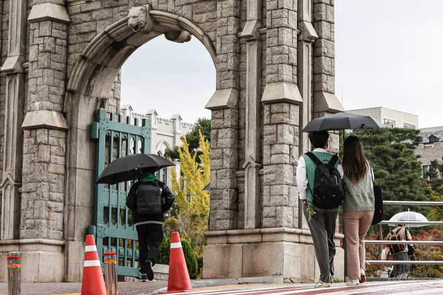 학생들이 서울 성북구 고려대학교에서 우산을 쓰고 걷고 있다. 연합뉴스