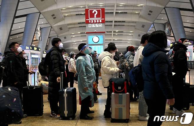 5일 코로나19 확산 속 중국 베이징 기차 역에서 방호복을 입은 승객이 줄을 서 있다. ⓒ AFP=뉴스1 ⓒ News1 우동명 기자