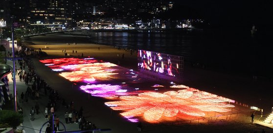 '어게인, 해운대 빛의 바다'를 주제로 한 '제9회 해운대 빛축제'가 부산 해운대해수욕장 백사장에서 개막돼 시민과 관광객들이 환하게 불밝힌 400m구간에 달하는 '빛 파도'를 구경하고 있다. 송봉근 기자