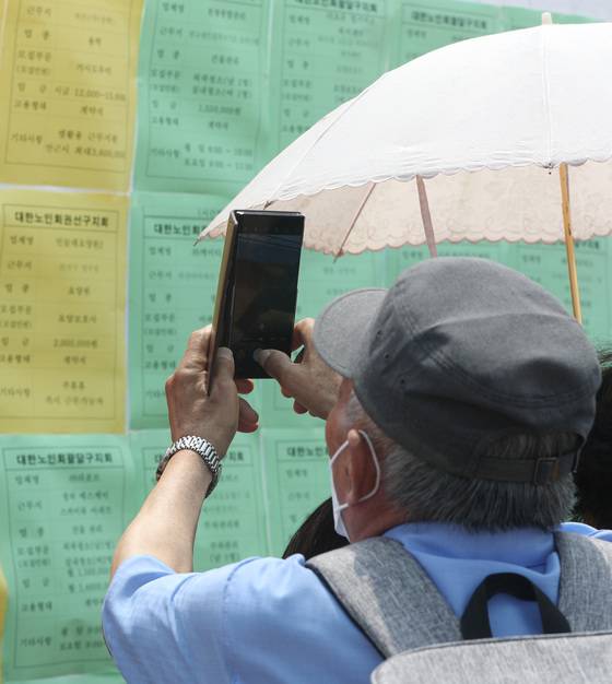 (수원=뉴스1) 김영운 기자 = 21일 오후 경기 수원시 팔달구 화성행궁에서 열린 ‘2022년 노인 일자리 채용 한마당’에서 어르신들이 구직활동을 하고 있다. 2022.6.21/뉴스1