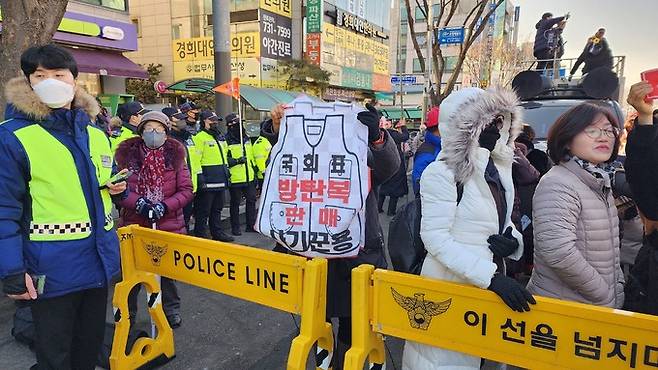 10일 경기 성남 수정구 수원지검 성남지청 건너편 인도에서 한 보수단체 참가자가 ‘국회표 방탄복 판매 사기꾼용’이라고 적힌 조끼를 들어보이고 있다. 김현우 기자