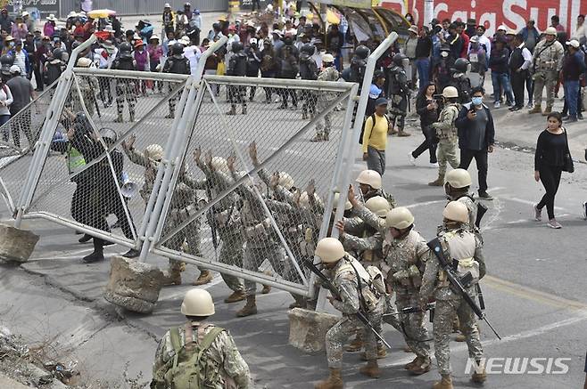 [아레키파=AP/뉴시스] 4일(현지시간) 페루 아레키파에서 페루 군인들이 시위대가 막아놓은 도로의 장애물을 치우고 있다. 2023.01.05.