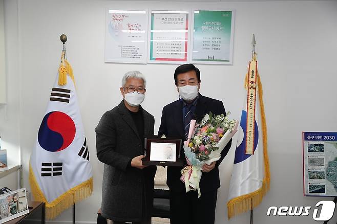 윤해복 부산시사회복지사협회장(왼쪽)이 최진봉 중구청장(오른쪽)에게 감사패를 전달하고 기념촬영을 하고 있다. (중구청 제공)