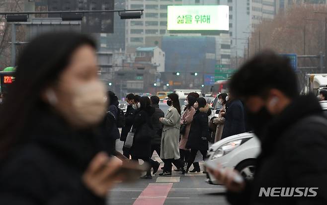 [서울=뉴시스] 김진아 기자 = 서울 및 수도권 미세먼지 상태가 '나쁨 수준'을 보이고 있는 9일 서울 광화문네거리에서 마스크를 쓴 시민들이 출근하고 있다. 2023.01.09. bluesda@newsis.com