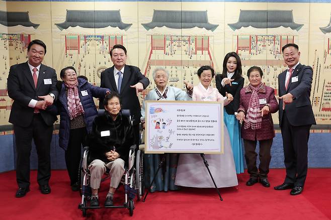 윤석열 대통령과 부인 김건희 여사가 12일 서울 용산 대통령실에서 '칠곡할매글꼴'을 만든 주인공인 칠곡 할머니 다섯 분을 초청해 기념촬영을 했다. 손가락으로 숫자 '7'을 만드는 칠곡군의 '럭키 칠곡' 포즈를 취했다. 왼쪽부터 정희용 국회의원, 이원순 할머니, 이종희 할머니, 윤석열 대통령, 추유을 할머니, 권안자 할머니, 김건희 여사, 김영분 할머니, 김재욱 칠곡군수./대통령실