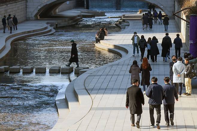 서울 지역 낮 최고 기온이 13도까지 올라 포근한 날씨를 보인 12일 서울 종로구 청계천 일대에서 시민들이 점심시간을 이용해 산책을 즐기고 있다. /뉴스1