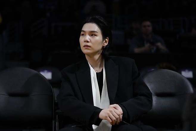 [서울=AP/뉴시스] 12일(이하 현지시간) 오후 미국 캘리포니아 주(州) 로스앤젤레스(LA) 크립토닷컴 아레나에서 열린 미국 프로농구(NBA) LA레이커스 대 댈러스 매버릭스의 경기를 관람하는 방탄소년단 슈가.