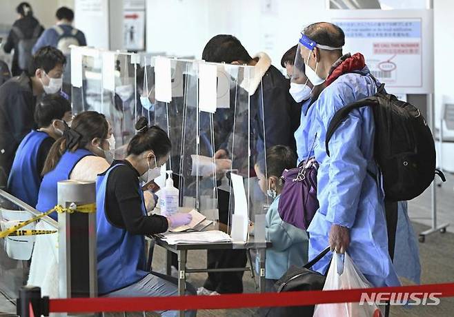 [나리타=교도·AP/뉴시스]지난 8일 중국 상하이발 승객들이 일본 수도 도쿄 인근 나리타공항에 도착 직후 코로나19 음성 판정을 받은 증명서를 제시하고 있다. 중국은 코로나19 관련 중국인 여행객 요건에 대한 보복으로 한국인이 관광이나 사업차 입국할 수 있는 비자 발급을 중단하고 있다. 2023.01.11