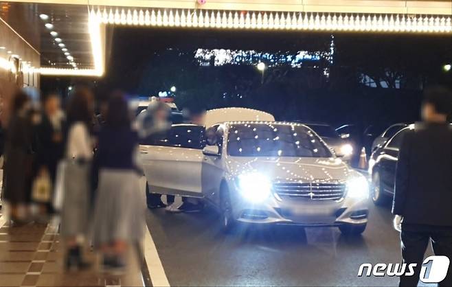 지난해 10월23일 부산 한 호텔에서 조직폭력배 '칠성파'의 전 두목 A씨가 팔순 잔치를 마치고 남성들의 부축을 받으며 차량에 탑승하고 있다.2022.10.23/뉴스1 노경민 기자