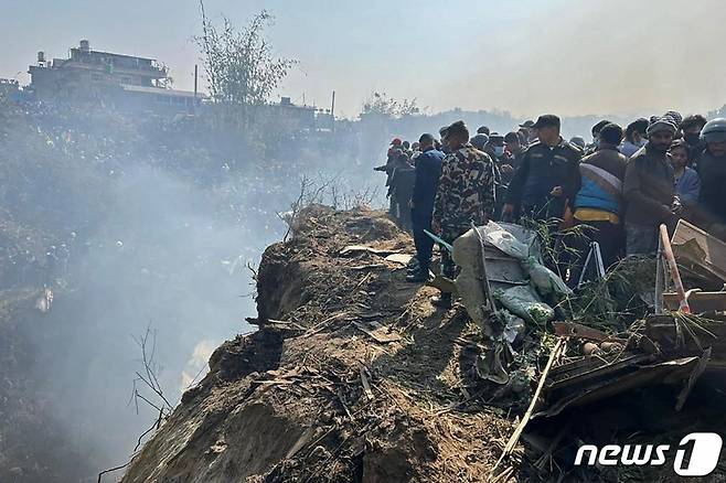 15일 네팔 포카라의 항공기 추락 사고 현장에서 구조대가 주변을 살펴보고 있다. 주네팔 한국 대사관 측은 해당 항공기에 한국 국적자 2명이 탑승한 것으로 보인다고 밝혔다. /AFPBBNews=뉴스1