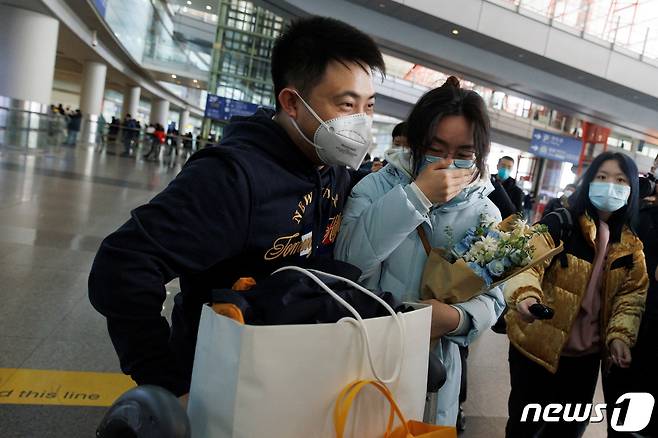 8일 중국 베이징 국제공항 입국장에서 재회한 사람들이 포옹하고 있다. 이날부터 중국 정부는 격리 없이 48시간 이내 코로나19 유전자증폭(PCR) 검사 음성 결과만 있으면 입국할 수 있도록 방역 빗장을 풀었다. ⓒ 로이터=뉴스1 ⓒ News1 권진영 기자