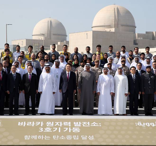 아랍에미리트(UAE)를 국빈 방문 중인 윤석열 대통령과 무함마드 빈 자이드 알 나하얀 대통령이 16일(현지 시각) 바라카 원자력 발전소 현장에서 열린 3호기 가동식에서 참석자들과 기념촬영을 하고 있다. /뉴시스