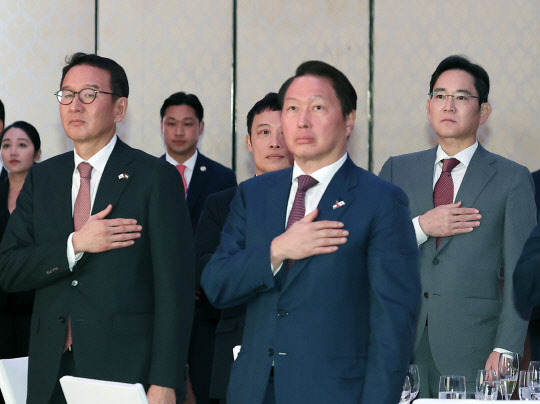 이재용(오른쪽 첫번째) 삼성전자 회장과 최태원(가운데) SK그룹 회장,허용수(왼쪽 첫번째) GS에너지 사장이 16일 오후(현지시간) 아랍에미리트(UAE) 아부다비 콘래드 아부다비 에티하드타워에서 열린 동행 경제인과의 만찬 간담회에서 국기에 경례를 하고 있다. 연합뉴스