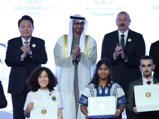 Korean President Yoon Suk Yeol, left, and United Arab Emirates President President Mohammed bin Zayed Al Nahyan, center, clap during the opening ceremony of the Abu Dhabi Sustainability Week as part of World Future Energy Summit 2023 in Abu Dhabi, UAE on Monday. [EPA/YONHAP]