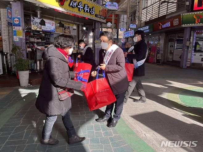 [창원=뉴시스] 홍정명 기자=중소벤처기업부 최열수 경남지방중소벤처기업청장이 17일 창원시 의창구 도계부부시장을 찾아 전통시장 이용 캠페인을 하면서 장바구니를 나눠주고 있다.(사진=경남중기청 제공) 2023.01.17. photo@newsis.com