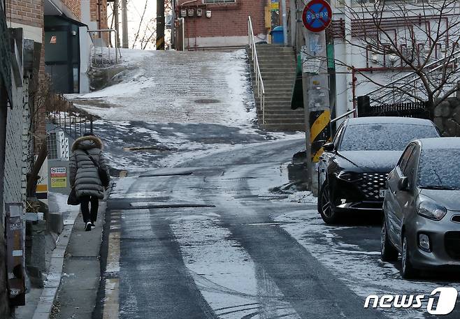 영하권 한파가 연일 이어지고 있는 28일 새벽에 눈이 내려 빙판길이 된 서울 마포구의 한 골목길에서 한 시민이 조심스럽게 발걸음을 옮기고 있다. 2022.12.28/뉴스1 ⓒ News1 박세연 기자