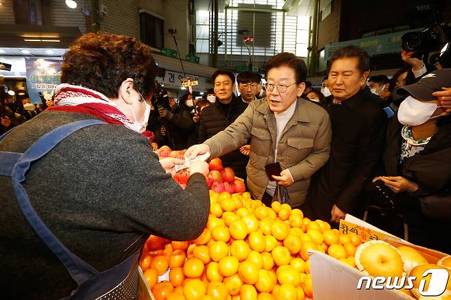 이재명 더불어민주당 대표가 설 명절을 앞둔 18일 오후 서울 마포구 망원시장을 찾아 식료품을 구매하고 있다. (공동취재) 2022.1.18/뉴스1 ⓒ News1 이재명 기자