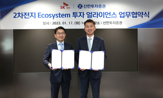 SK On chief administrative officer Choi Young-chan, left, and Shinhan Securities CEO Kim Sang-tae, take a photo after signing an agreement to cooperate on battery investment Tuesday. [SK ON]