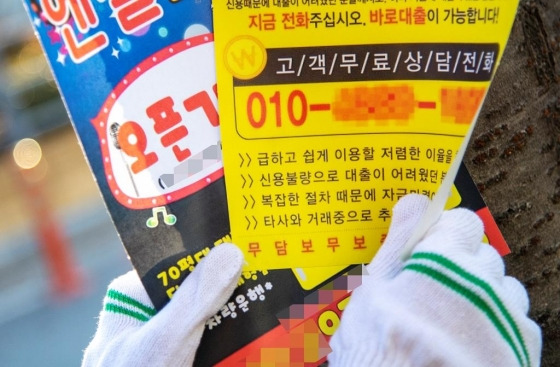 ▲지난 17일 주민이 이태원 일대에 붙어있는 불법전단지를 수거하고 있다/사진=용산구