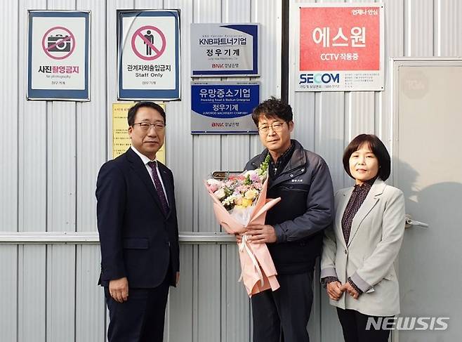 [창원=뉴시스] 홍정명 기자=BNK경남은행 창원영업본부 신태수(오른쪽) 상무가 18일 정우기계 박정천 대표와 '파트너기업' 현판식 기념촬영을 하고 있다.(사진=BNK경남은행 제공)2023.01.18. photo@newsis.com