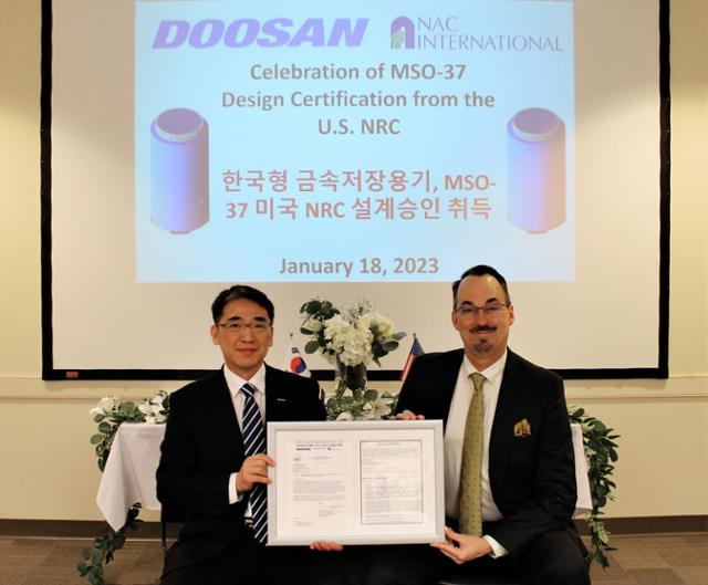 두산에너빌리티가 미국 NAC(Nuclear Assurance Corporation)와 공동 개발한 사용후핵연료 금속 저장용기가 미국 원자력규제위원회(NRC) 설계승인을 취득했다고 19일 밝혔다. 사진은 18일(현지시간) 미국 애틀랜타에 위치한 NAC 본사에서 열린 설계승인 취득 기념식에서 조창열(왼쪽) 두산에너빌리티 상무와 켄트 콜(Kent Cole) NAC사 사장이 기념사진을 촬영하는 모습. 두산에너빌리티 제공