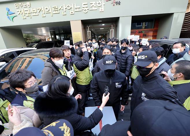 지난 18일 오후 서울 영등포구 민주노총 전국보건의료산업노동조합 사무실에서 국가보안법 위반 혐의 관련 압수수색을 마친 국정원 직원들이 압수품을 옮기고 있다. 연합뉴스