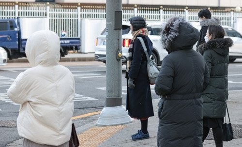 서울 아침 최저기온이 영하 8도까지 떨어지며 추운 날씨를 보인 지난 16일 오전 시민들이 서울 종로구 광화문역 인근에서 외투 모자를 쓰고 신호를 기다리고 있다. [사진 출처 = 연합뉴스]