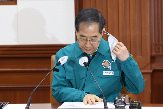 한덕수 국무총리가 20일 오전 정부서울청사에서 열린 코로나19 중앙재난안전대책본부 회의에서 마스크를 벗고 있다. 연합뉴스