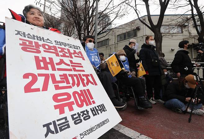 전국장애인차별철폐연대(전장연) 회원이 19일 오후 서울 서초구 남부터미널 앞에서 열린 시외버스 이동권 촉구 집회에서 팻말을 들고 있다. [연합]