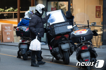 한 배달노동자가 서울시내에서 점심시간 음식을 배달하고 있다.  ⓒ News1 유승관 기자