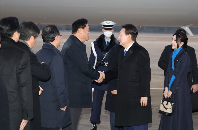 윤석열 대통령이 21일 오전 경기도 성남 서울공항으로 귀국해 정진석 국민의힘 비상대책위원장과 악수하고 있다. 연합뉴스