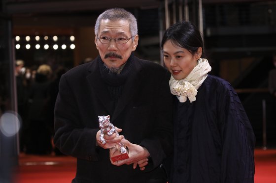 홍상수 감독(왼쪽)이 지난해 2월 베를린영화제에서 은곰상을 받은 뒤 배우 김민희와 기념 촬영을 하고 있다. AP=뉴시스
