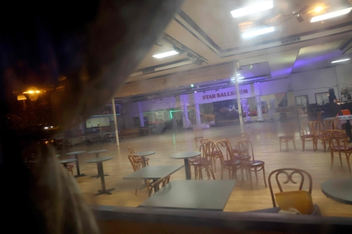 21일(현지시간) 총기난사가 일어난 미국 캘리포니아 몬터레이파크의 댄스 교습소 내부를 한 시민이 들여다보고 있다. AFP연합뉴스