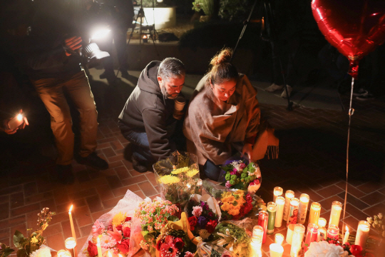 23일(현지시간) 미국 캘리포니아주 몬터레이파크에서 시민들이 음력 설 행사 도중 발생한 총기난사 사건 희생자들을 추모하는 촛불을 밝히고 있다. 로이터 연합뉴스
