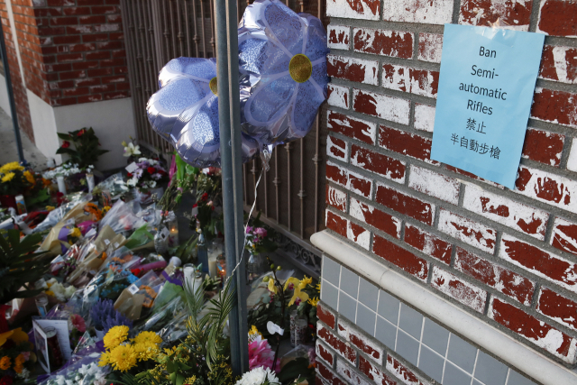 ▲23일(현지시각) 미국 캘리포니아주 몬터레이 파크에 위치한 스타 댄스 스튜디오 앞에 21일 이 장소에서 발생한 총기난사 희생자를 추모하는 꽃들이 놓여 있다. 벽에는 "반자동 총기를 금지하라"는 벽보가 붙여 있다. ⓒEPA=연합뉴스 