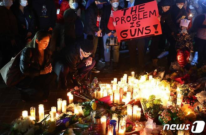 24일(현지시간) 미국 캘리포니아주 몬터레이파크 시민들이 음력 설 연휴 발생한 총기 난사 사망자들을 추모하며 촛불을 밝히고 있다. 지난 21일 몬터레이파크의 한 댄스 강습소에서 총격이 벌어져 11명이 숨지고 9명이 다쳤다. 당국은 이날 사망자 명단을 공개하고 대다수가 고령의 중국계 이민자들이라고 밝혔다. 2023.1.24. ⓒ AFP=뉴스1 ⓒ News1 김성식 기자