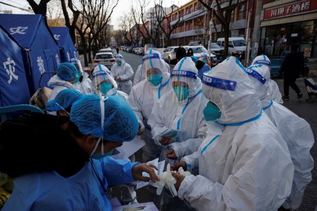지난해 12월 8일 중국 베이징에서 코로나19 감염자가 지속적으로 발생하는 가운데 방역요원들이 입주민이 자가격리 중인 건물을 둘러보는 근무를 시작하기 전 새 보호장비를 지급받고 있다. 로이터연합뉴스